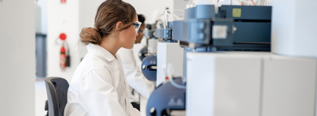 woman in lab coat working on machine stem