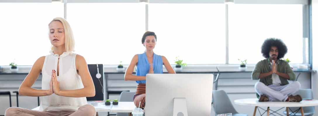 Executives doing yoga in office How to create a supportive working environment for your employees’ mental health