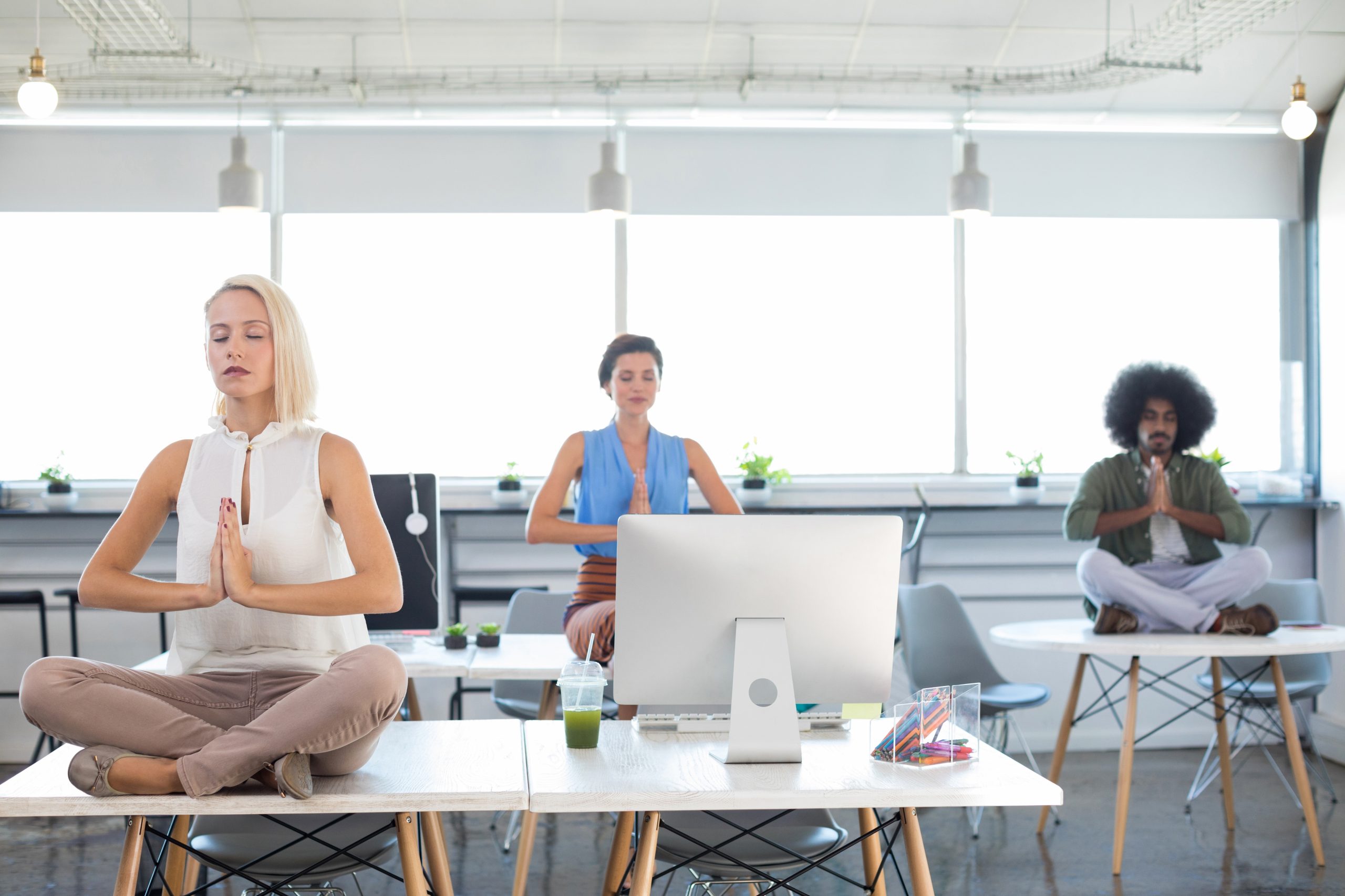 Executives doing yoga in office How to create a supportive working environment for your employees’ mental health