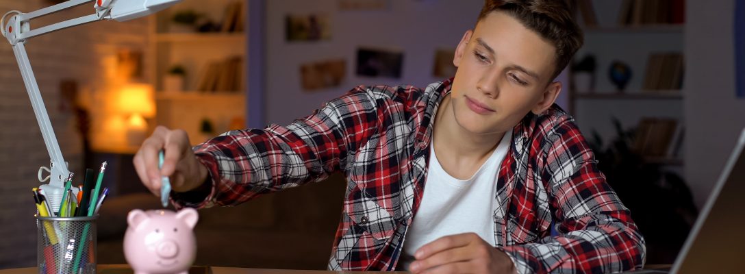 Teenager holding euro banknote putting it to piggyback, financial education Are your IT infrastructure salaries competitive?