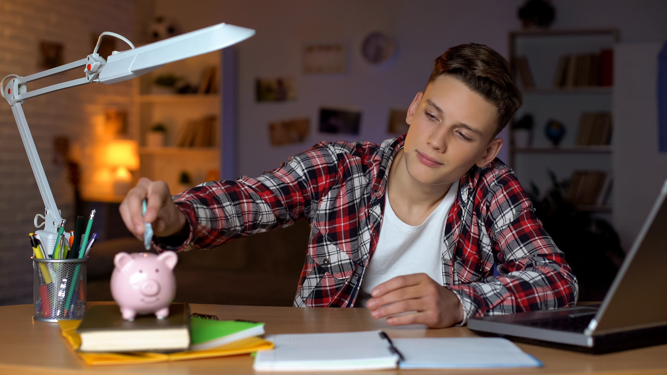 Teenager holding euro banknote putting it to piggyback, financial education Are your IT infrastructure salaries competitive?