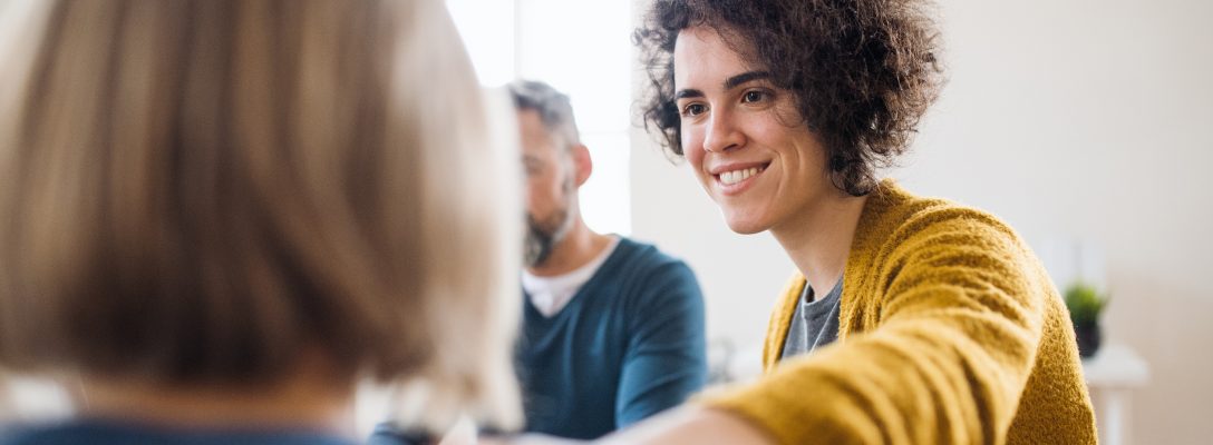 Men and women sitting in a circle during group therapy, supporting each other. 5 creative ways to reduce stress in the office and for remote teams