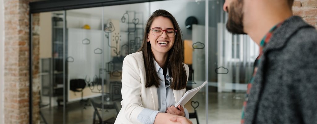 Handshaking and smiling candidly at a job interview How to nail competency-based interview questions asked by hiring managers