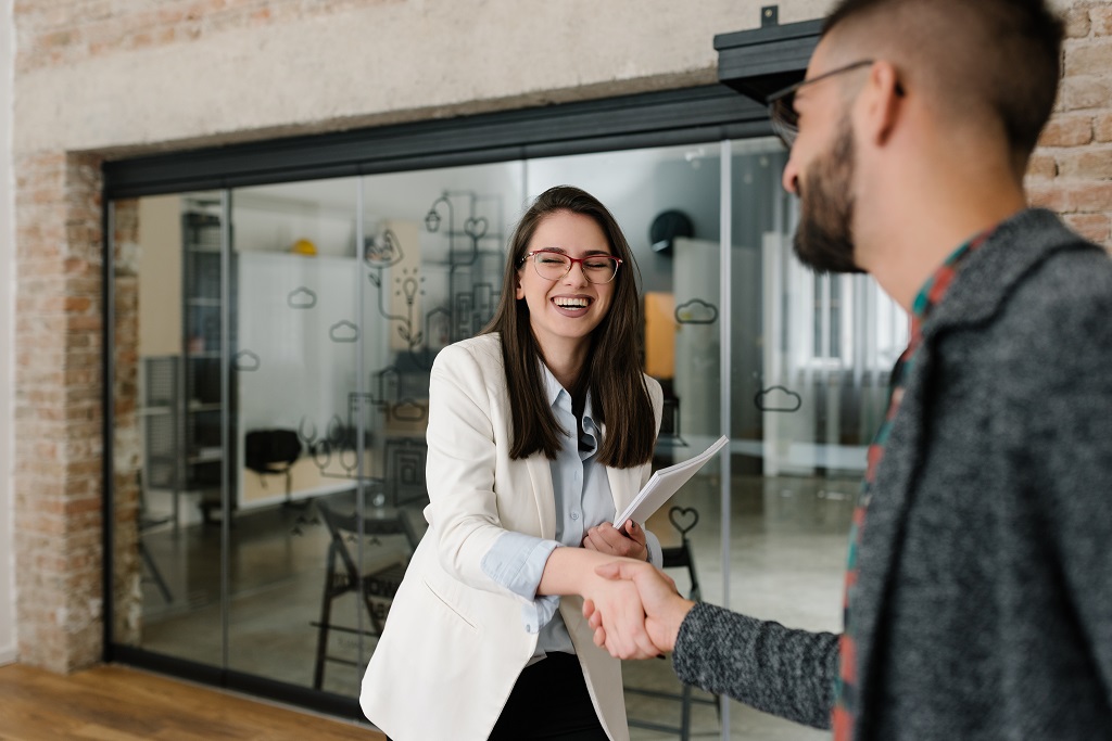 Handshaking and smiling candidly at a job interview How to nail competency-based interview questions asked by hiring managers