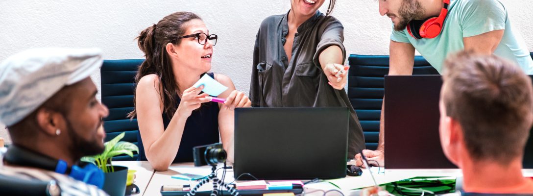 Millenial friends employees group workers on computer at startup How to attract Gen Z candidates to your IT roles
