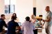 Group of people sat working around a desk with one person standing